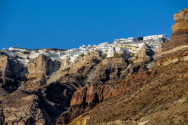 Santorini Adası'nda kayalık sahil ve deniz beyaz şehir görüntüsü