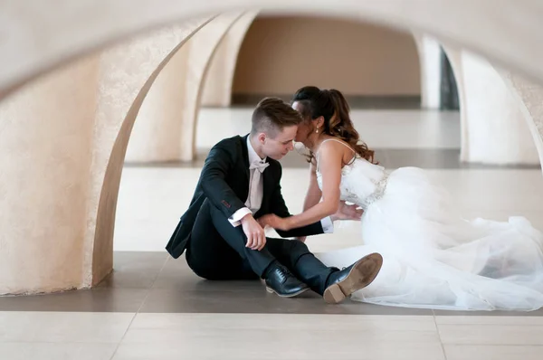 Novomanželé Sedí Podlaze Oblouku Jejich Svatební Den Svatebních Šatech — Stock fotografie