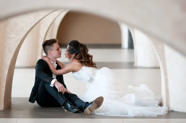 Novomanželé Sedí Podlaze Oblouku Jejich Svatební Den Svatebních Šatech — Stock fotografie