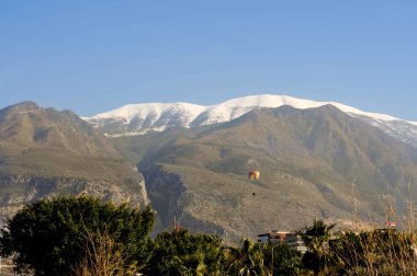 paroplan güneşli bir günde dağlardaki gökyüzünde uçan