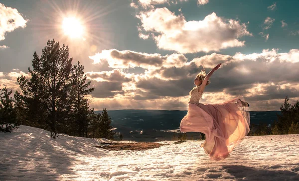 Chica en un vestido de salto en las montañas contra un cielo nublado — Foto de Stock