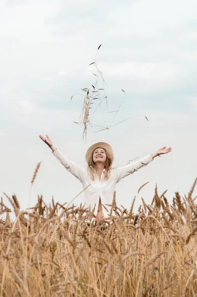 Buğday tarlasındasarışın kadın gökyüzüne buğday kulakları atıyor