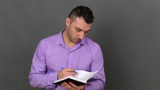 Un jeune homme feuillette et examine le journal . — Video