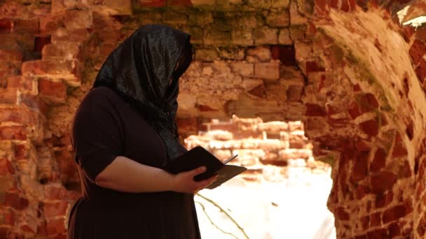 Старая разрушенная церковь. Женщина, листающая Библию . — стоковое видео