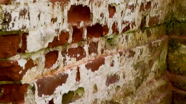 파괴된 붉은 벽돌 벽의 일부가 비스듬 히보인다. — 비디오