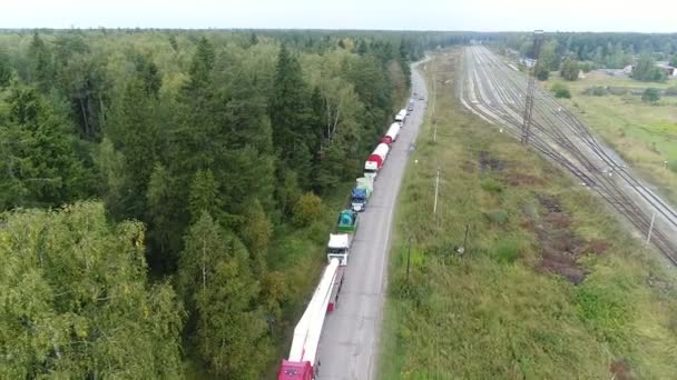 Widoczne z góry, duża kolumna ciężarówek stoi na drodze. — Wideo stockowe