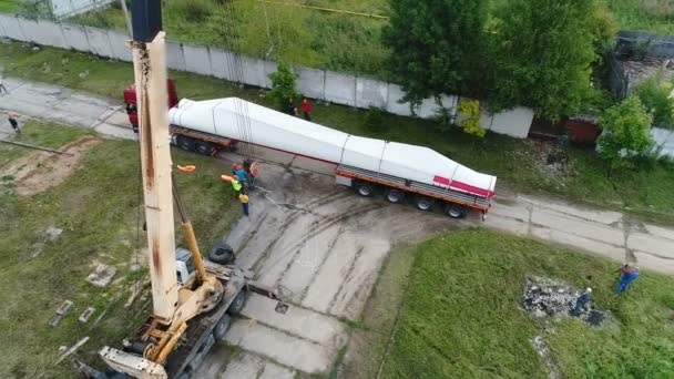 Desde arriba vemos un camión con una gran carga tirando bajo una grúa . — Vídeos de Stock