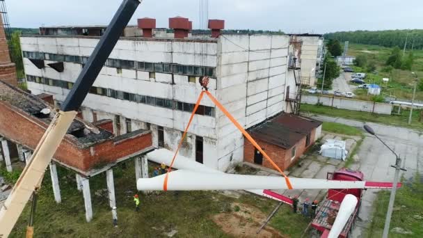 一台工业起重机把一个巨大的风力发电机组的叶片固定在吊索上. — 图库视频影像