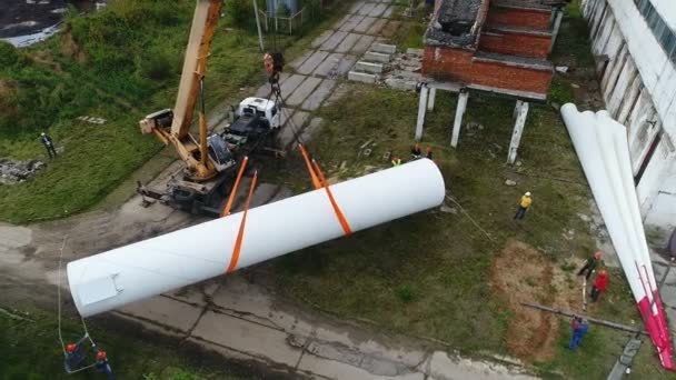 Heben einer riesigen Stütze eines Windgenerators mit einem Industriekran. — Stockvideo