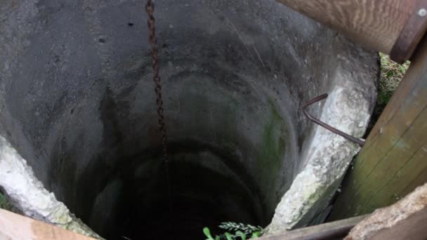Ein mit Wasser gefüllter Eimer steigt langsam aus dem Brunnen. — Stockvideo