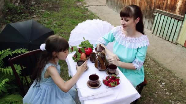 Дівчина в красивій сукні п'є чай з матір'ю . — стокове відео