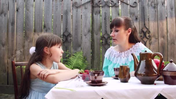 Kız ve annesi masada oturuyor ve güzel bir sohbet ediyorlar.. — Stok video