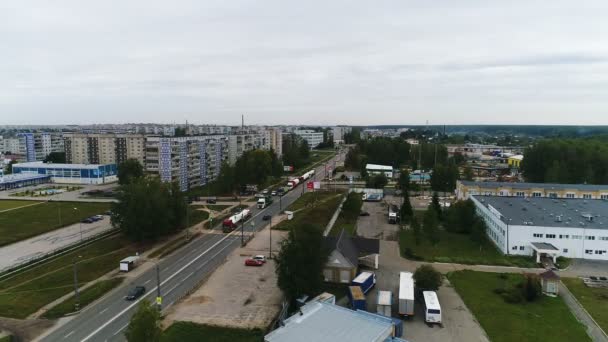 Eine LKW-Kolonne fährt die Straße am Stadtrand entlang. — Stockvideo