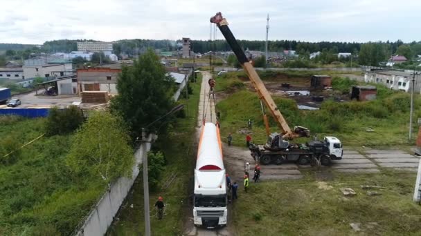 Le quadcopter vole autour du camion de déchargement de la grue. — Video