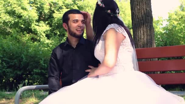Nevěsta v bílých šatech hladí ženicha po hlavě. — Stock video