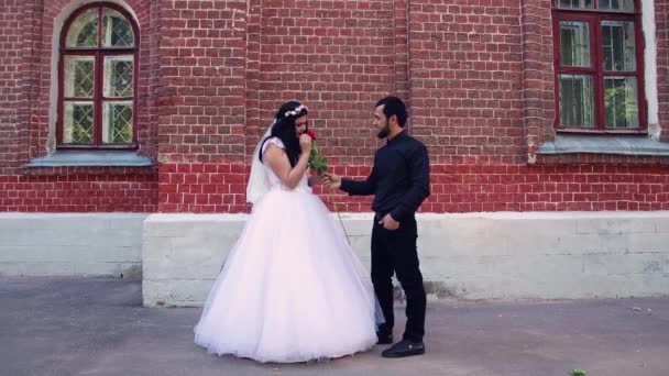 Uma noiva em um vestido branco e um noivo em uma camisa preta. — Vídeo de Stock
