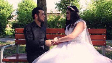 Genç evliler bankta oturup birbirlerine hayran olurlar..