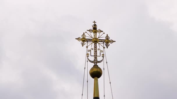 Gold, orthodox, Kirchenkreuz vor grauem Himmel. — Stockvideo