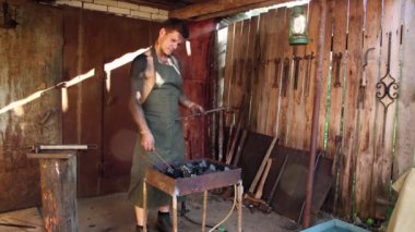 Bir adam demir çubukları demir ocağına koyar..