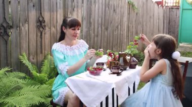 Anne ve kızı oturur ve ekşi, kırmızı böğürtlen yer..