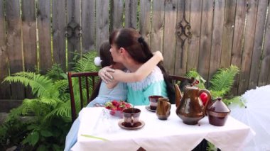 Anne kızının başını okşar ve ona sarılır..