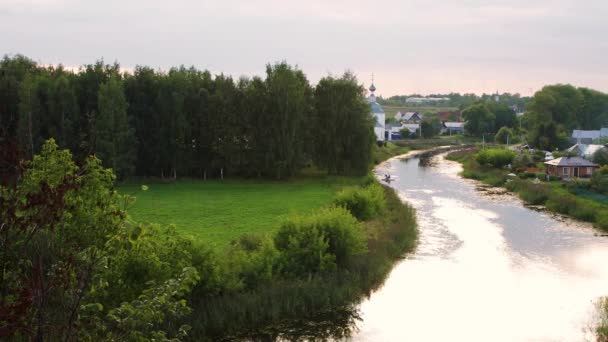 Panorama di un bel sobborgo con un campo, fiume, chiesa e case rurali. — Video Stock
