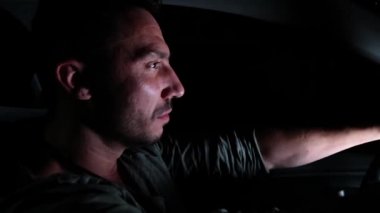 Genç bir adam gece bir araba kullanıyor..