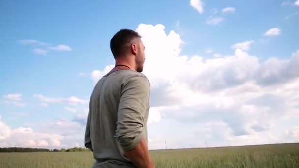 Un homme se tient sur le fond d'un ciel bleu avec des nuages. — Video