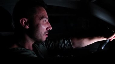 Genç bir adam gece araba kullanıyor.. 