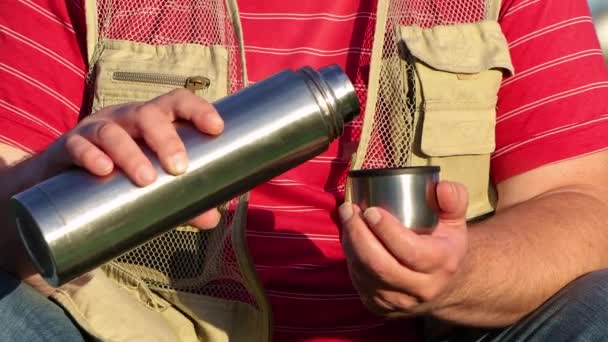 Mužské ruce nalévají čaj z kovové termosky. — Stock video