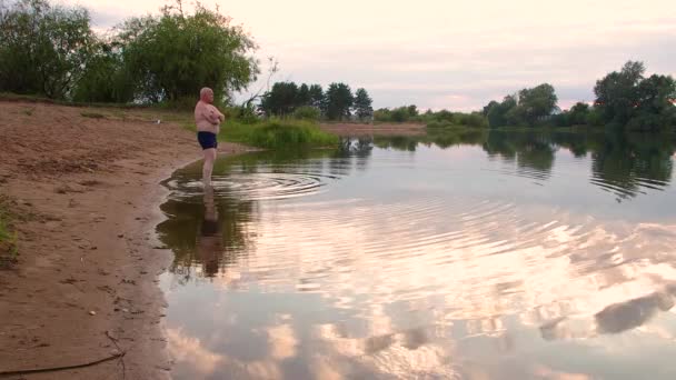 호수에 사는 한 젊은이가 차가운 물로 들어가다. — 비디오