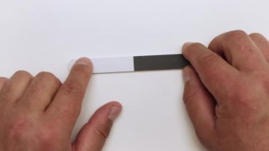 Mans elleri bir tırnak törpüsü tutuyor, onu inceliyoruz.. 