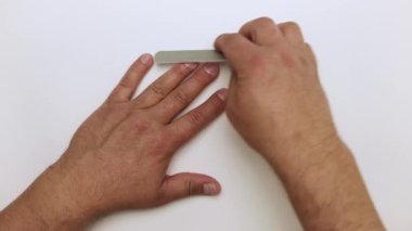 Bir tırnak törpüsüyle, erkeklerin elleri yüzük parmağını tutar..