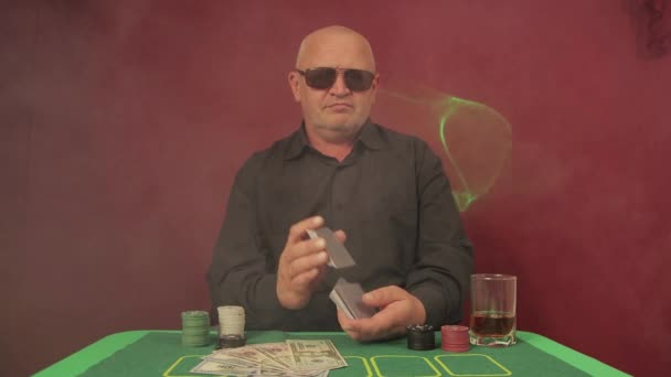 Человек в казино за игорным столом тасует карты — стоковое видео