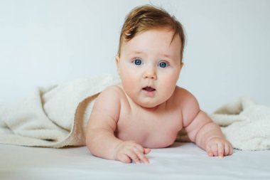 Yüzünde havluyla göbeğine uzanmış şirin bir bebek.