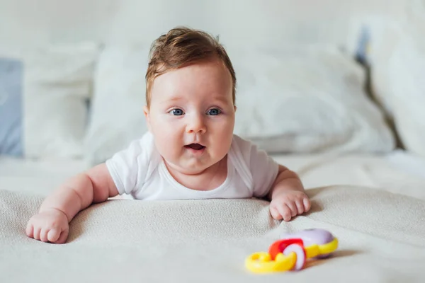 Pequeno Bebê Deitado Barriga Cama Branca Chegando Brinquedo — Fotografia de Stock