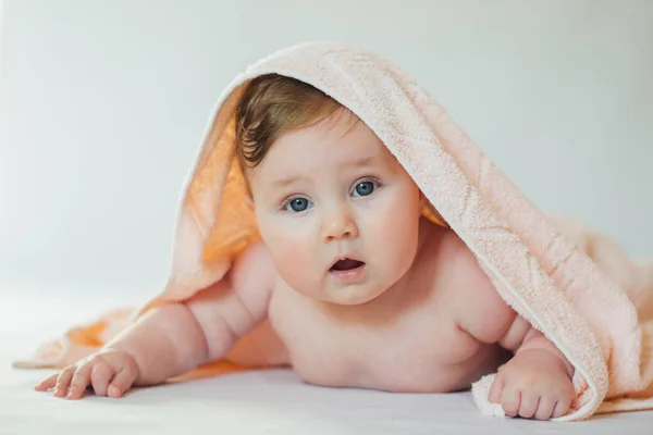 Yüzünde havluyla göbeğine uzanmış şirin bir bebek.