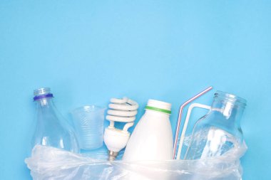 Mavi arka planda farklı tipte çöpler. Atık ve geri dönüşüm konsepti sıralanıyor. Ekoloji ve çevre bakımı. Üst görünüm düzlüğü kopyalama alanı ile yatıyordu.