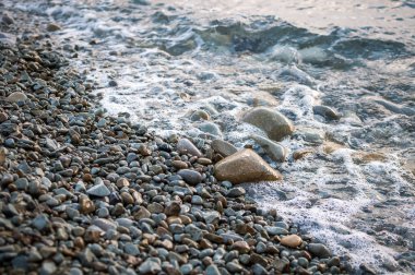 Sahilde, büyük taşlar wav tarafından yıkanmış