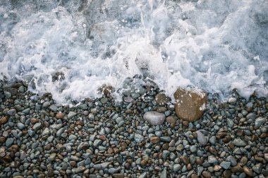 Sahilde, büyük taşlar wav tarafından yıkanmış