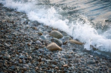 Sahilde, büyük taşlar wav tarafından yıkanmış