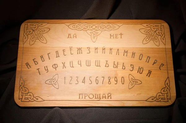 Ouija tahtası, üzerinde siyah bir adam sarı
