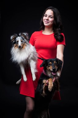 Kızlar köpekler üzerinde siyah adam ile kırmızı elbiseler