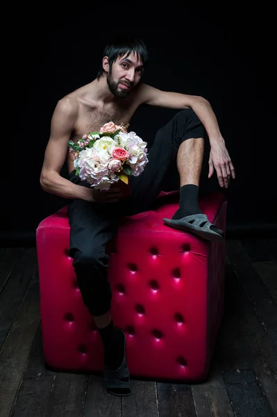 Young man with flowers on black background