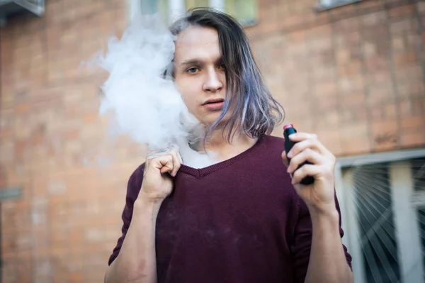 Portrait of a young man in the smoke of cigarettes — Stock Photo, Image