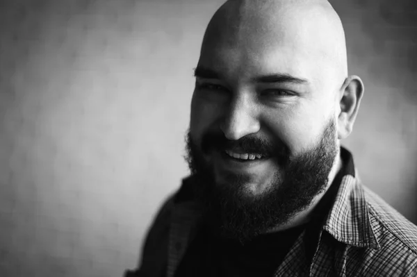 Portrait of a bald man in a shirt with a beard