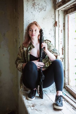 Elinde silah tutan bir kızın güzel portresi