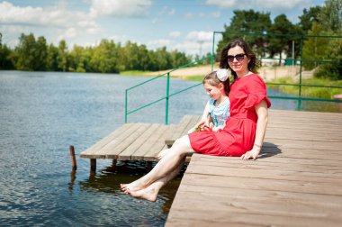 sevimli küçük kız ve annesi bir Güneş çim üzerinde eğlenmek