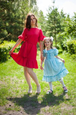 sevimli küçük kız ve annesi bir Güneş çim üzerinde eğlenmek