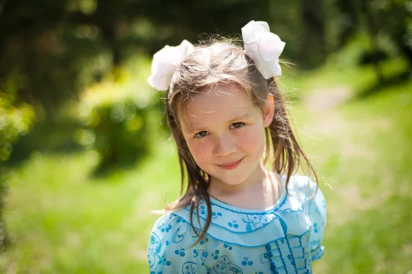 Niedliches kleines Mädchen, das Spaß beim Spazierengehen in einem sonnigen Park hat — Stockfoto